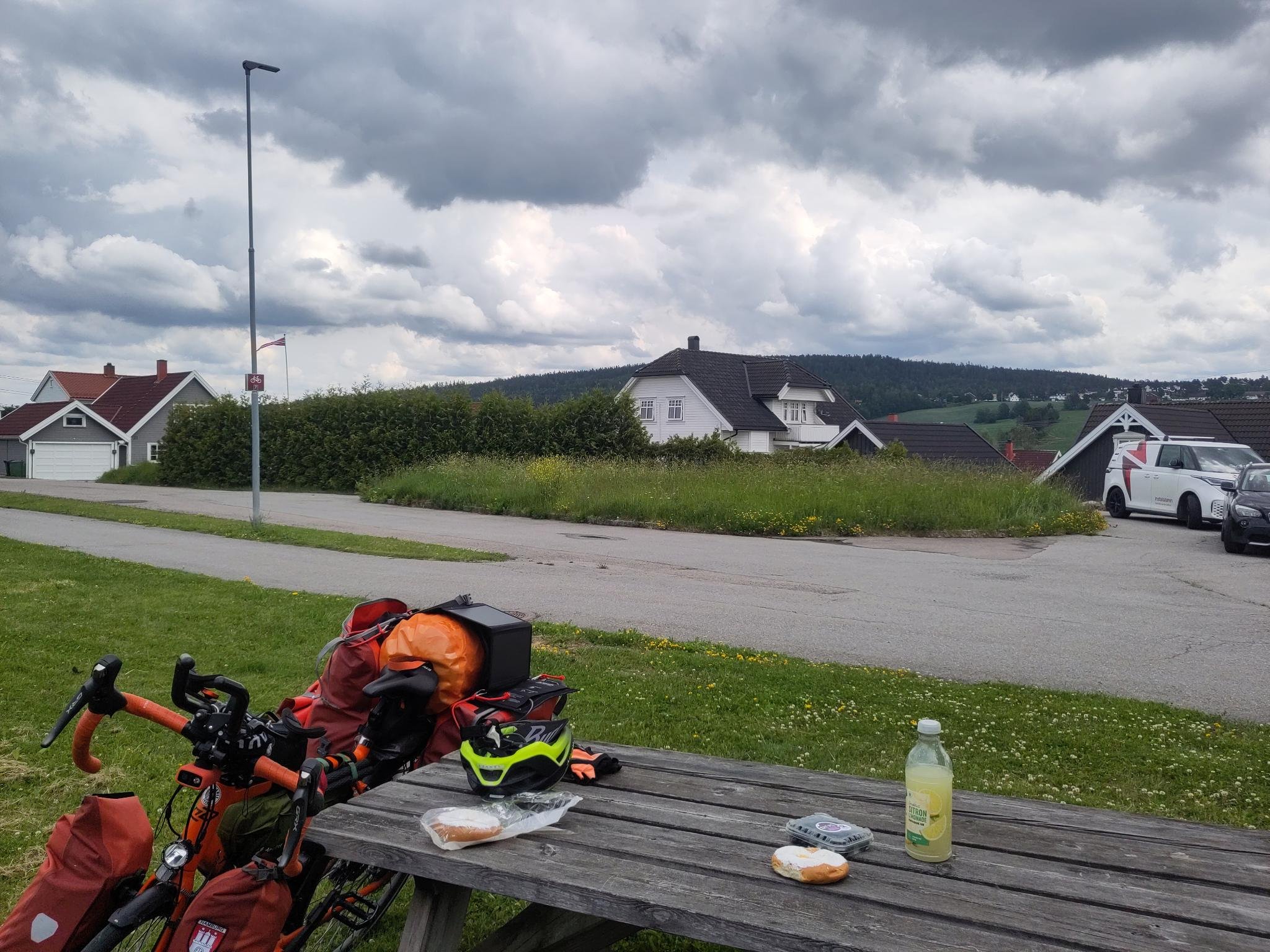 Bank mit Tisch: Darauf essen. Im Hintergrund norwegische Häuser und Berge